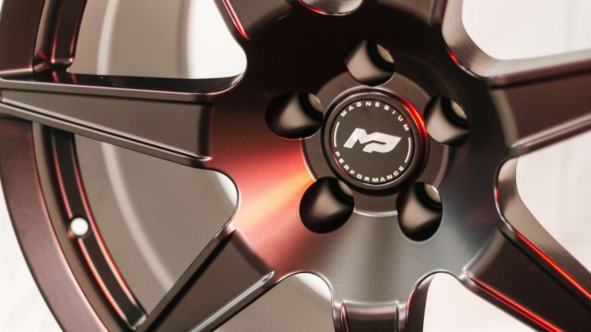 Close-up of MP forged magnesium wheels highlighting lightweight monoblock construction designed to reduce rotational mass and improve lap times on track.