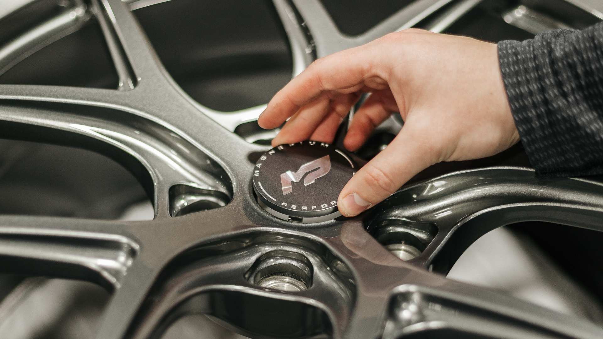 Close-up of MP Wheels forged magnesium aftermarket performance wheels during assembly, highlighting precision engineering and lightweight construction for improved handling and braking.